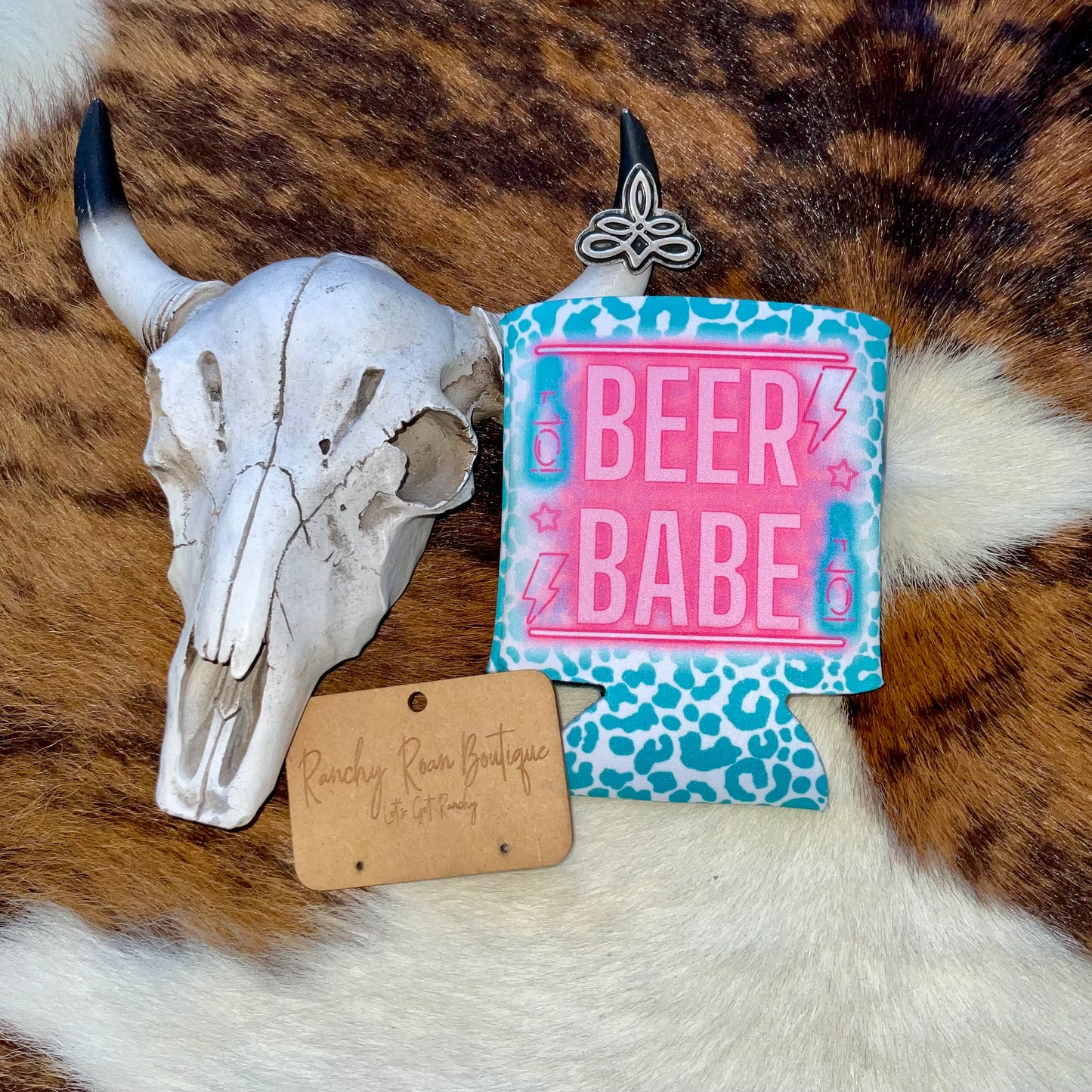Western-style can cooler with neon Beer Babe lettering, available in regular and slim sizes, with or without fringe.
