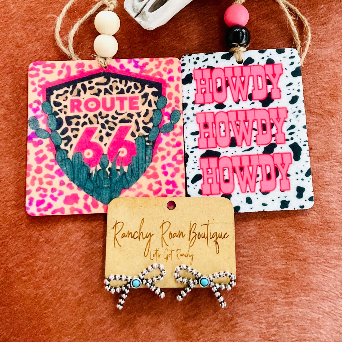 Route 66 felt air freshener with a leopard print and cactus design, displayed next to a Western skull for a rustic aesthetic.