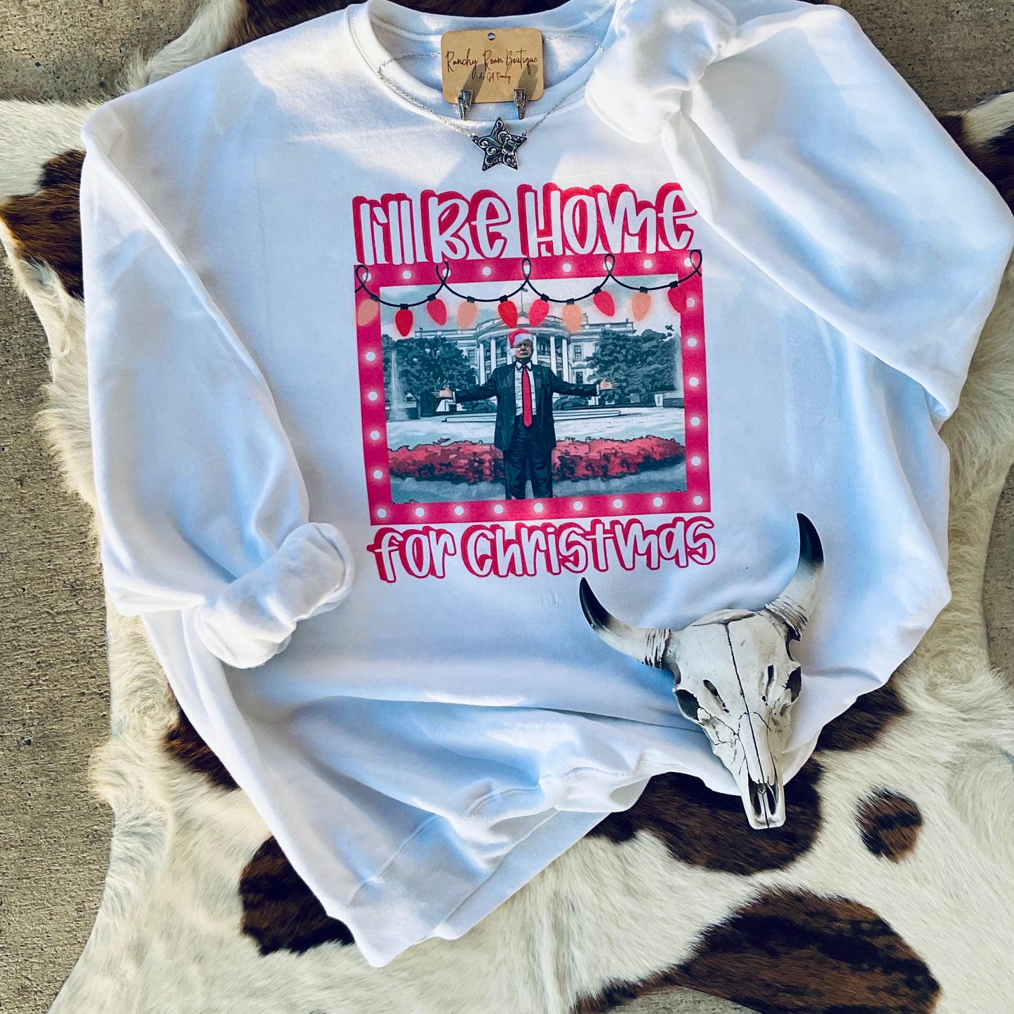 Full view of the white sweatshirt with a festive graphic, perfect for showcasing in holiday boutique collections.