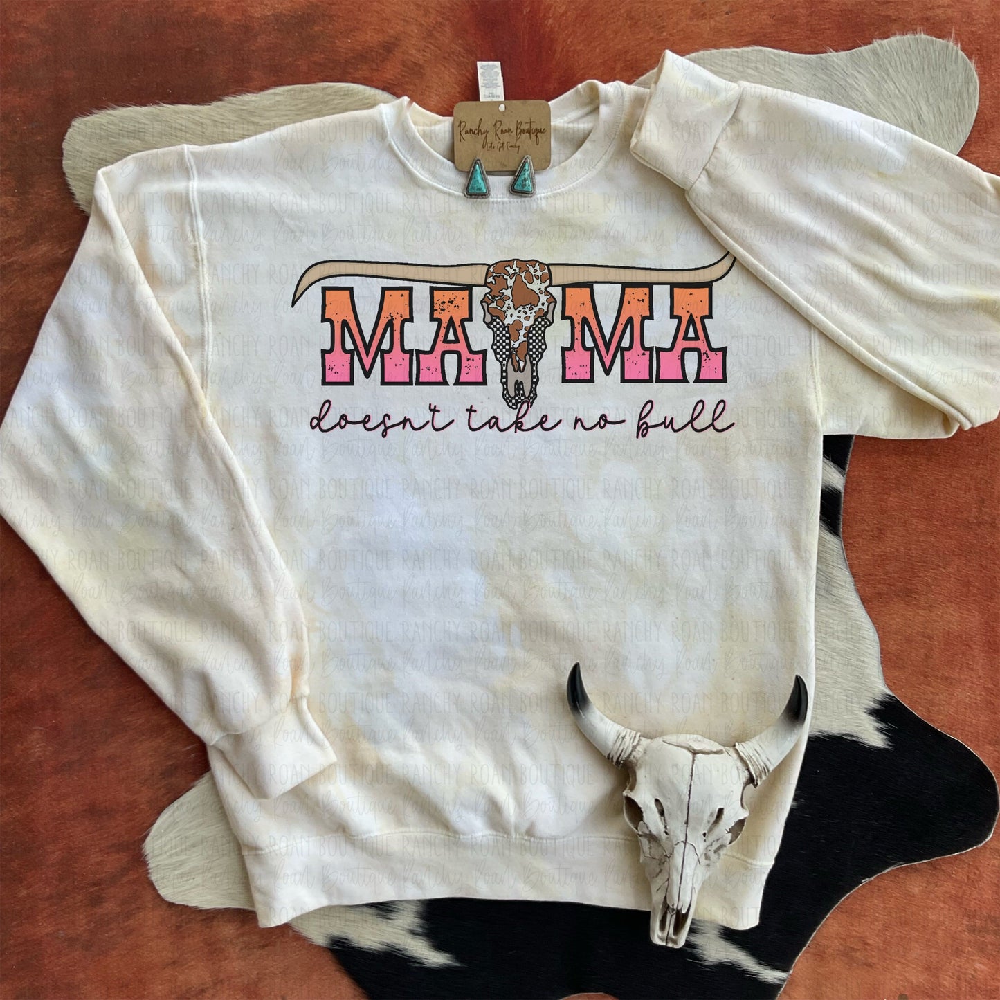 White sweatshirt dyed in varying shades of sandstone and brown, featuring “Mama Don’t Take No Bull” sublimation graphic, displayed flat.