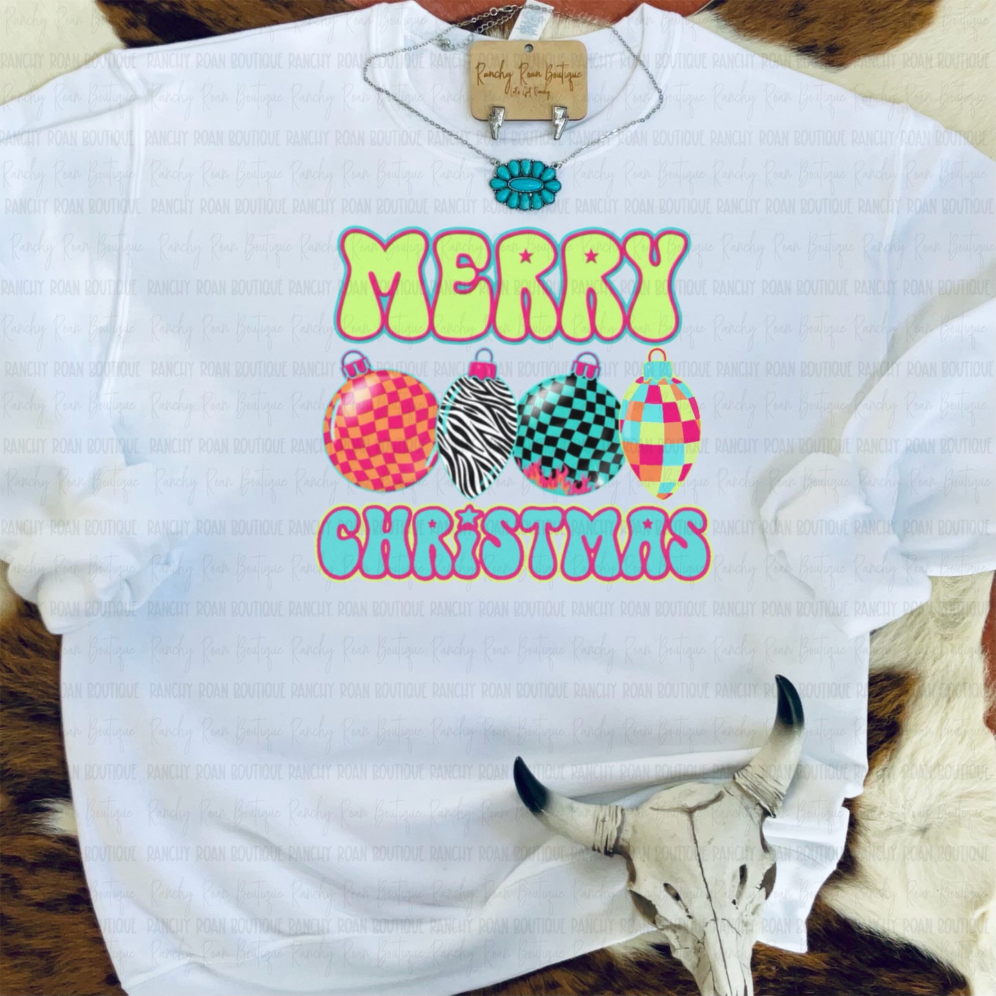 White sweatshirt with 'Merry Christmas' text and colorful ornaments on a fur background