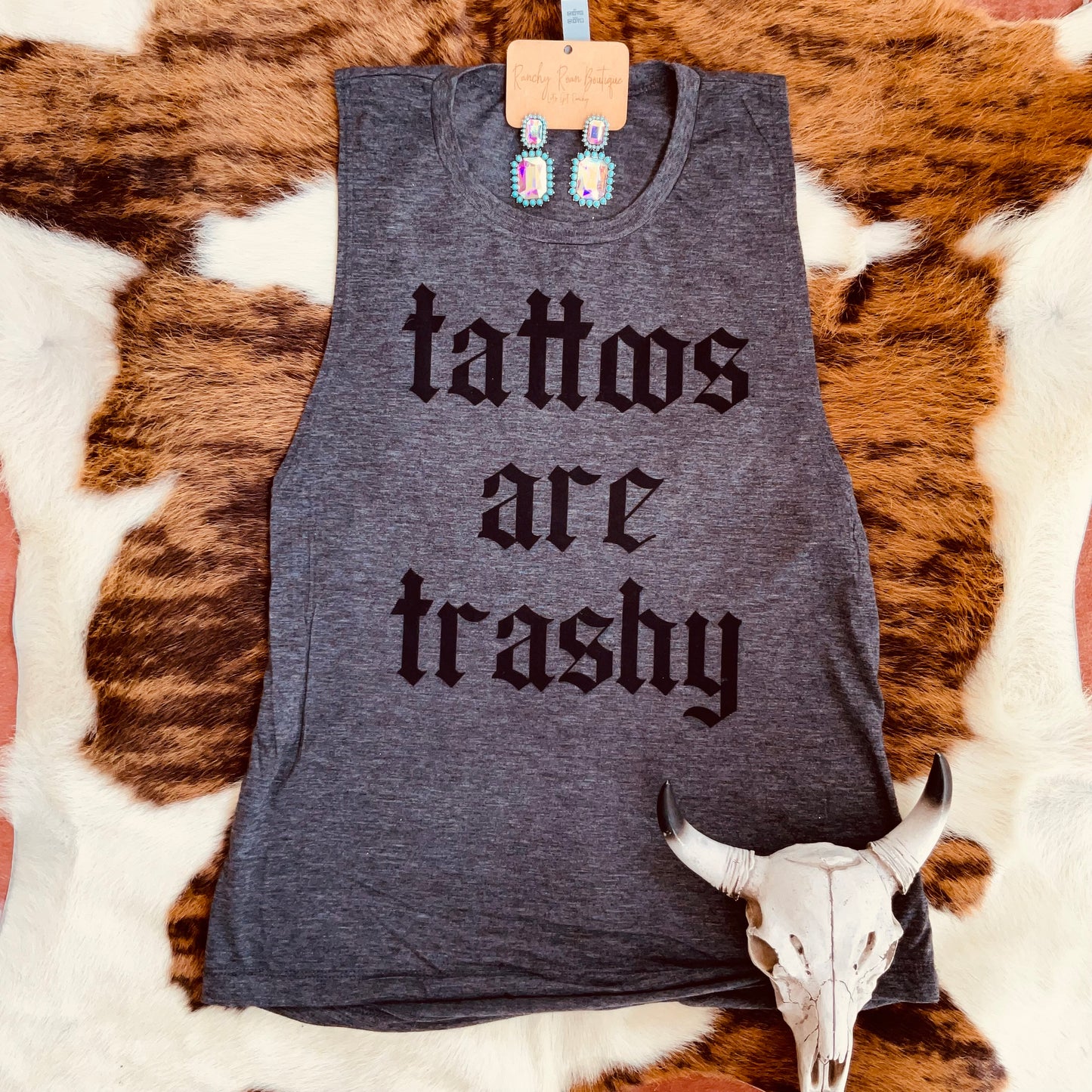 Tattoos Are Trashy Festival Muscle Tank featuring bold gothic Western lettering on a soft, relaxed-fit muscle tank.