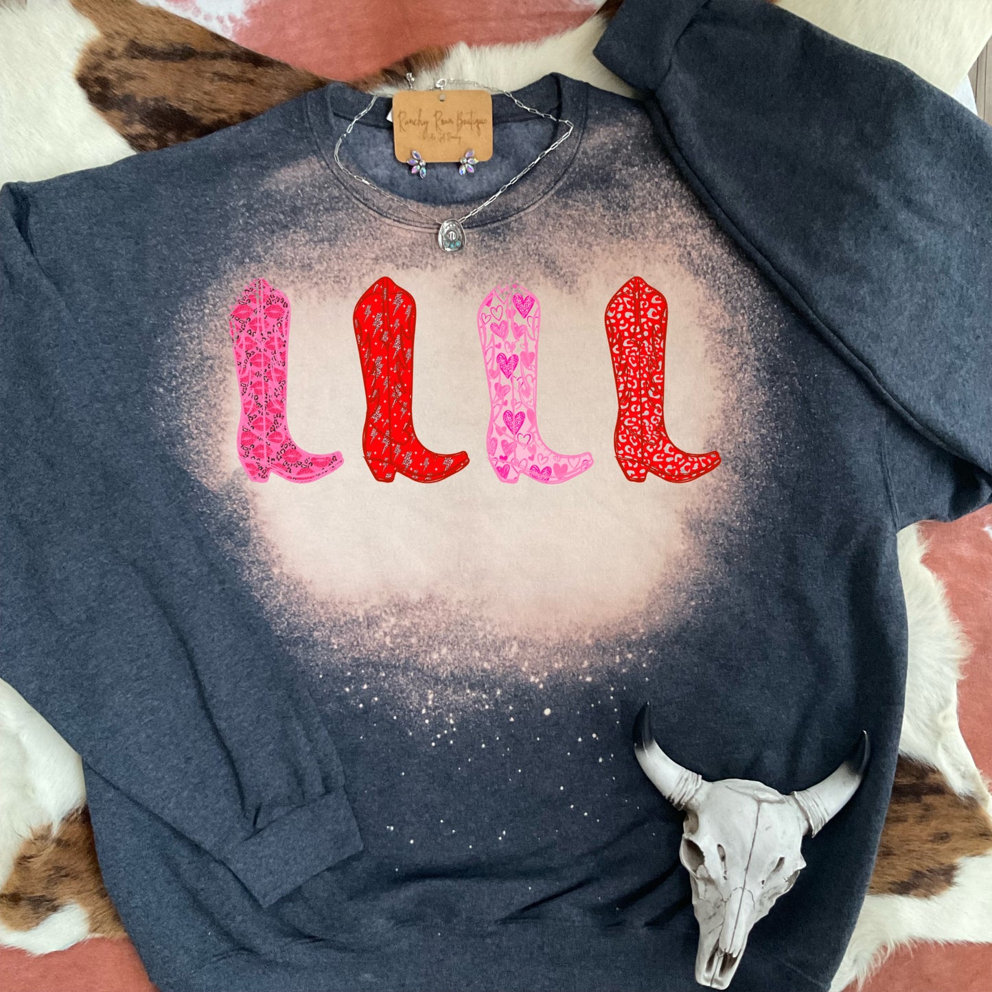 Charcoal bleach-dyed sweatshirt featuring a sublimation Valentine-themed boots design. Perfect for boutique buyers.
