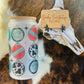 Cowhide Christmas Ornaments Frosted Glass Tumbler with bamboo lid featuring turquoise, red, and cowhide ornament designs on fur background.