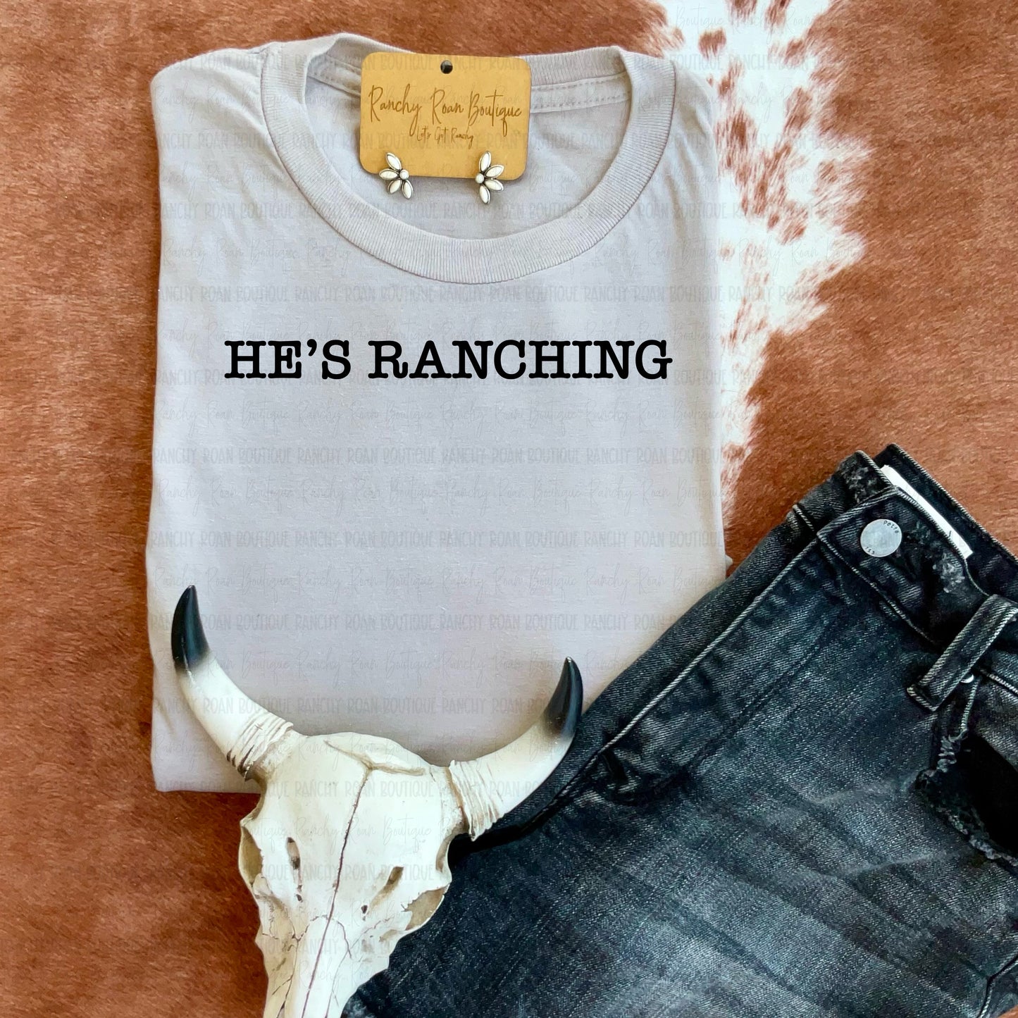  Sand sweatshirt with “He’s Ranching” in black lettering on cowhide background.