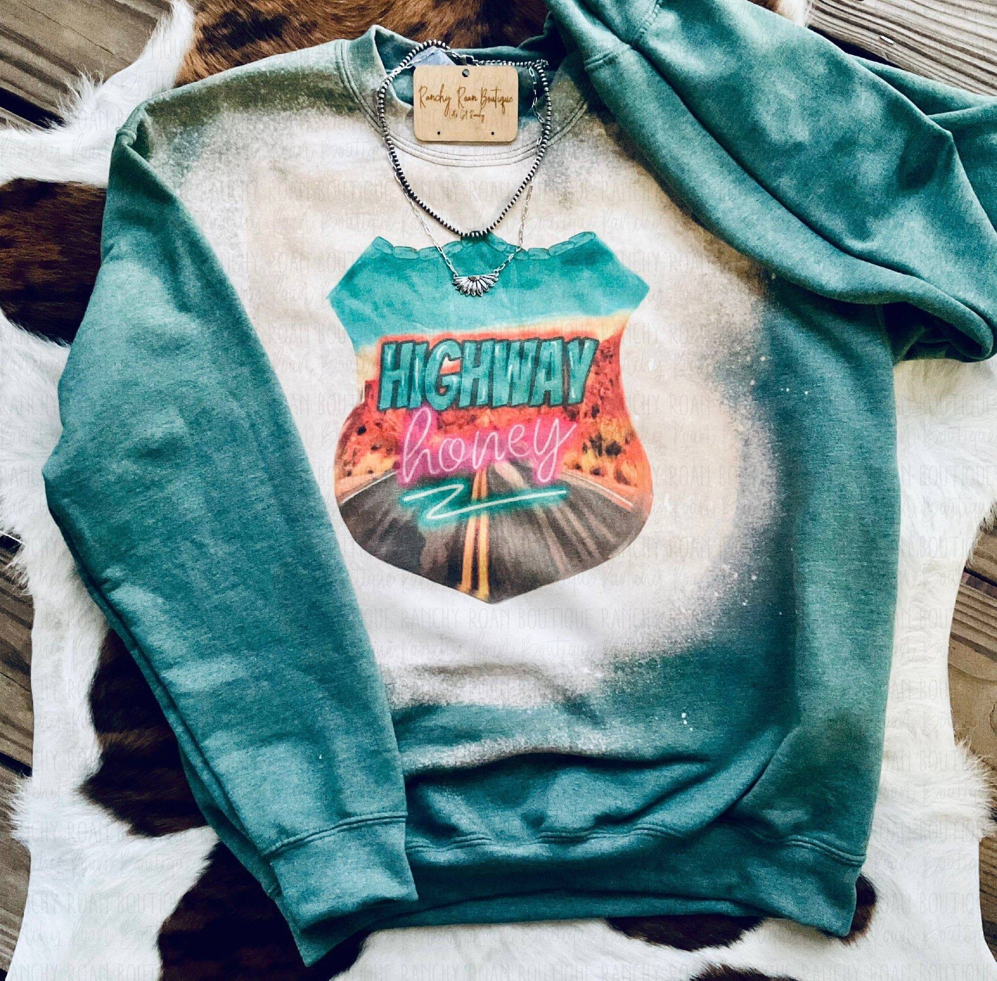 Highway Honey Western Graphic Sweatshirt featuring a bold highway graphic with neon “Highway Honey” text on a bleached background, styled with Western accessories.