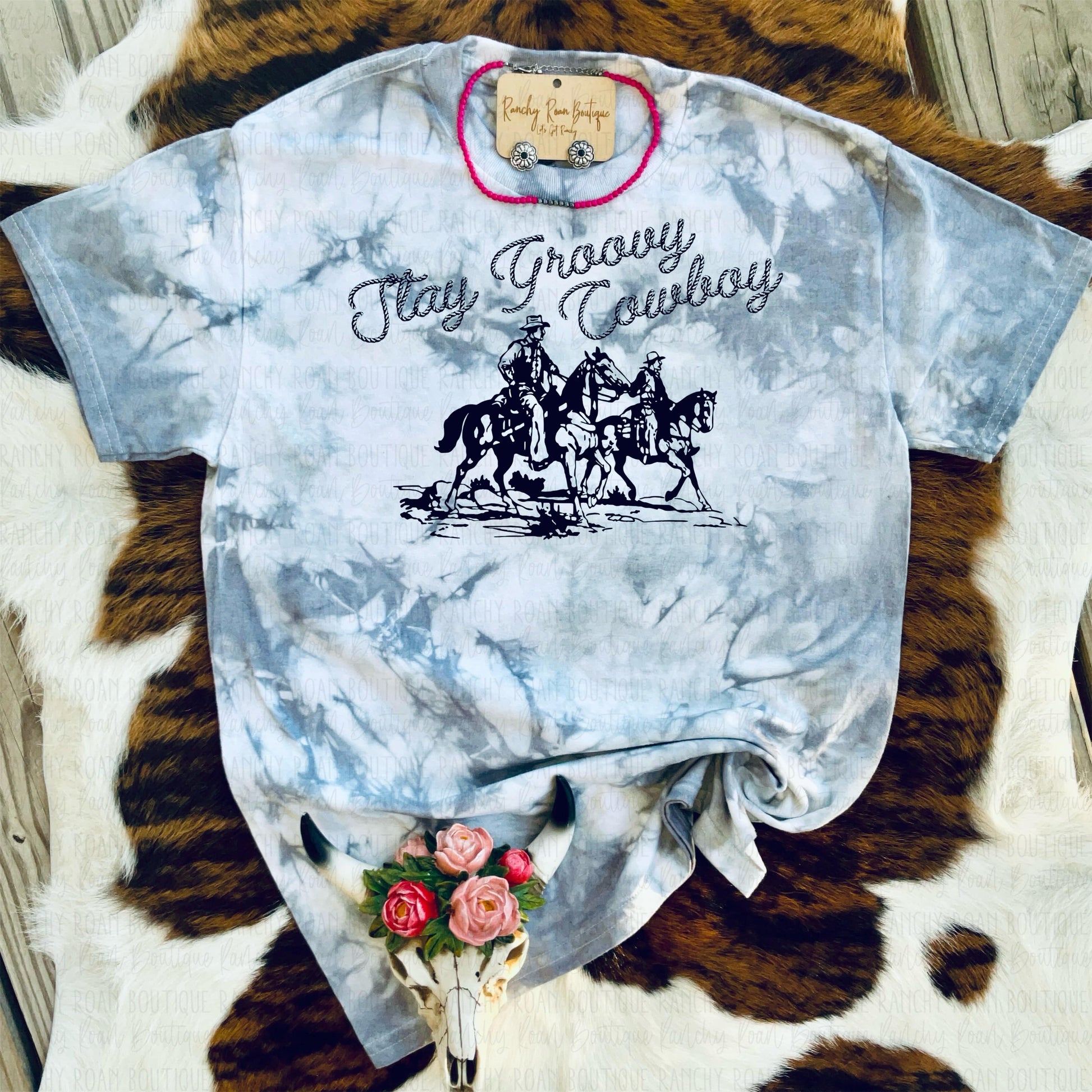 Hand-dyed T-shirt with shades of grey and graphite, featuring “Stay Groovy Cowboy” sublimation graphic with a cowboy riding a horse, displayed flat.