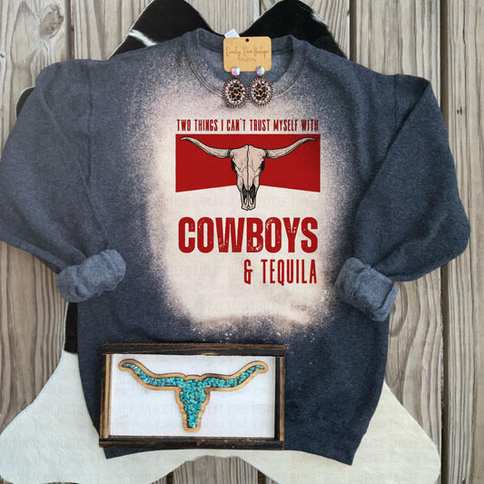 Black heather bleached sweatshirt with “Two Things I Can’t Trust Myself With Cowboys &amp; Tequila” sublimation graphic featuring a boho bull skull, displayed flat.