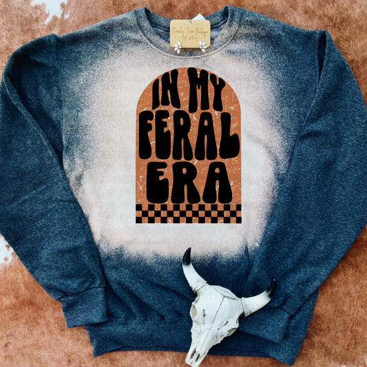 In My Feral Era sweatshirt with a retro-style graphic, displayed with a decorative cow skull on a cowhide rug.