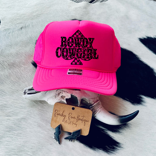 Neon Pink Rowdy Cowgirl Trucker Hat with Spade Graphic” - Vibrant trucker hat featuring a checkerboard spade graphic, styled with a Western cow skull prop.