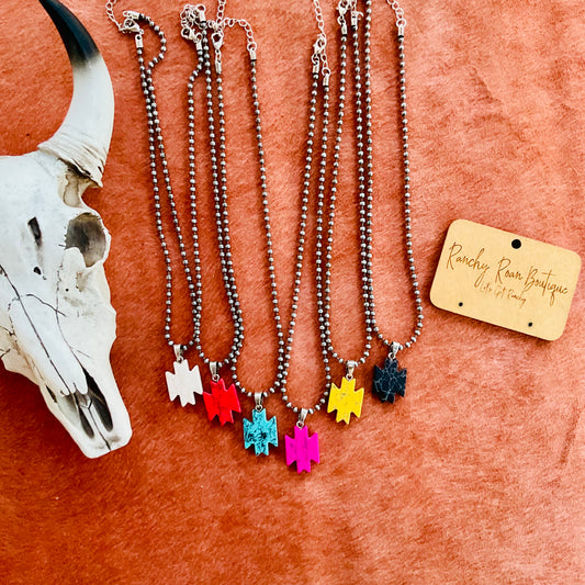 Western Aztec pendant necklace in burnished silver with an adjustable 16” chain and 3” extension, displayed against a rustic backdrop.