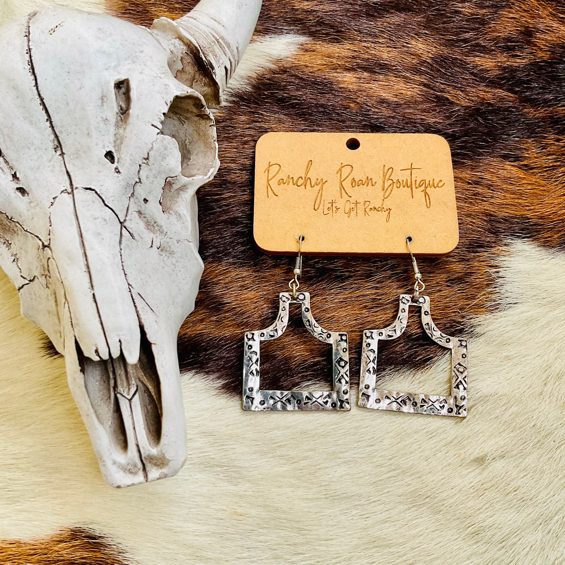  Close-up of Western Cattle Tag Earrings showing intricate stamped details and burnished silver finish.