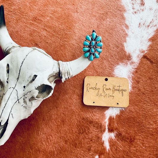 Western Design Turquoise Cuff Ring with intricate design, displayed on a rustic background with a cow skull.