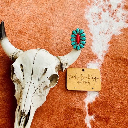 Western Design Turquoise and Red Cuff Ring with intricate design, displayed on a rustic background with a cow skull.