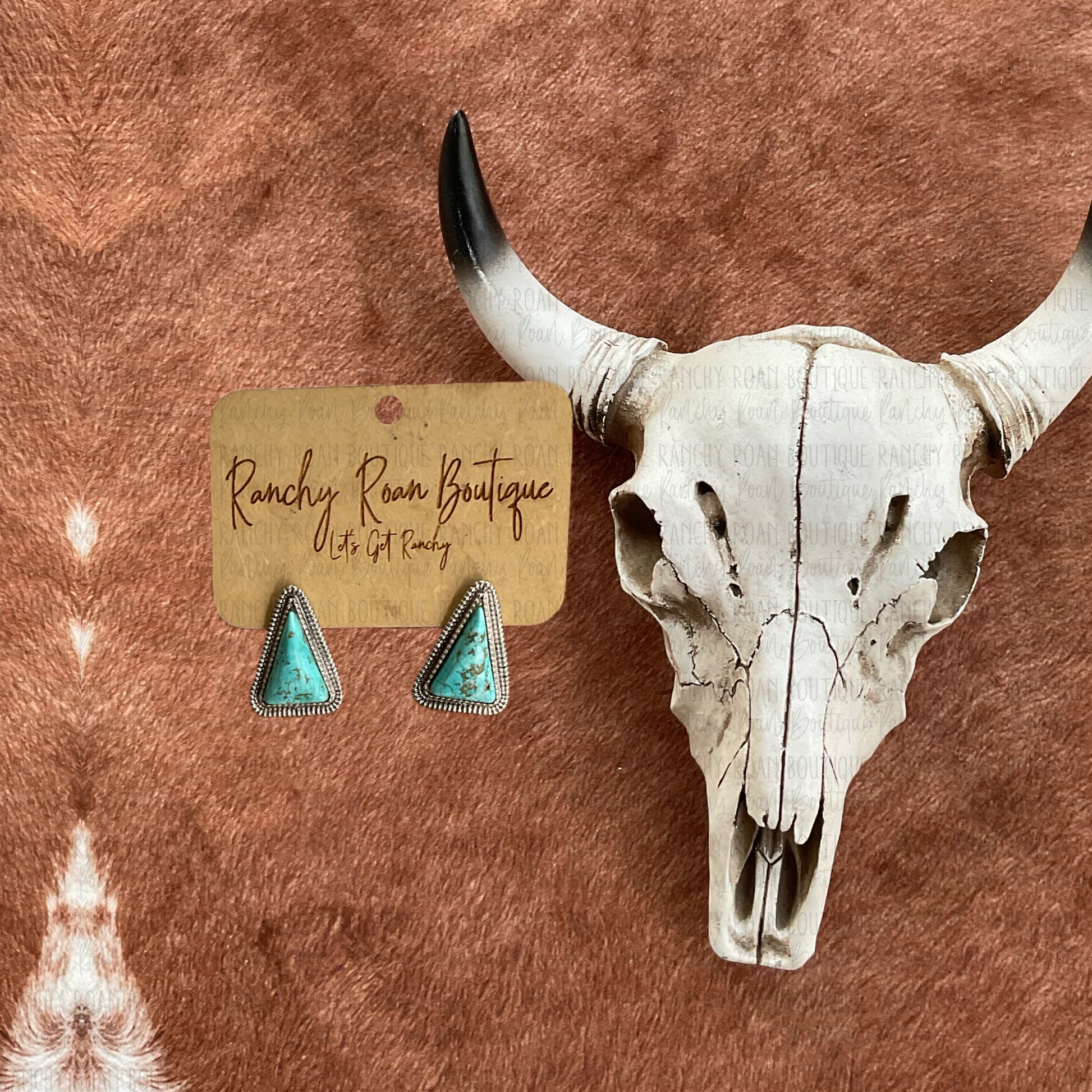 Western Stone Stud Triangle Earrings
On a rustic cowhidebackground with a cow skull 